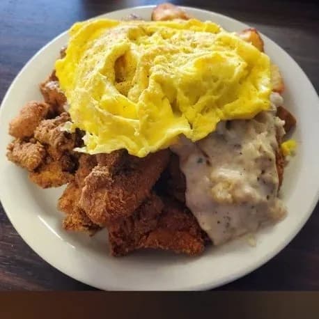 Chicken fried steak topped with scrambled eggs and cream gravy.